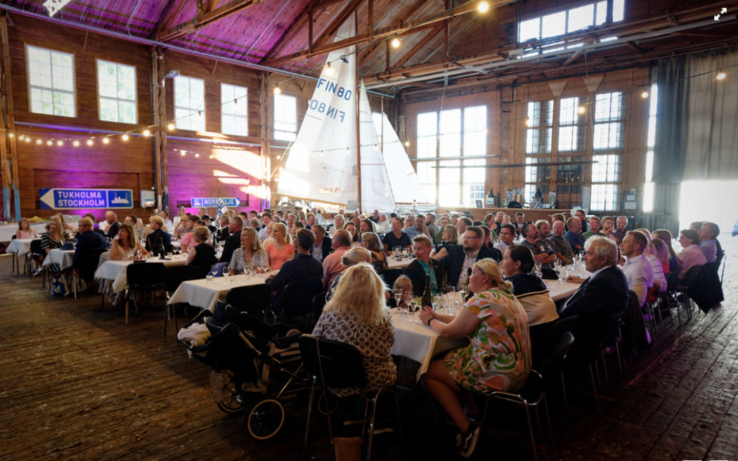 Regatta dinner in a historic wooden hall with a classic sailboat on display