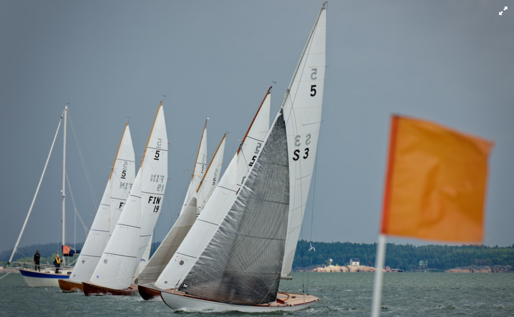 5m class fleet at the start line with orange race committee flag